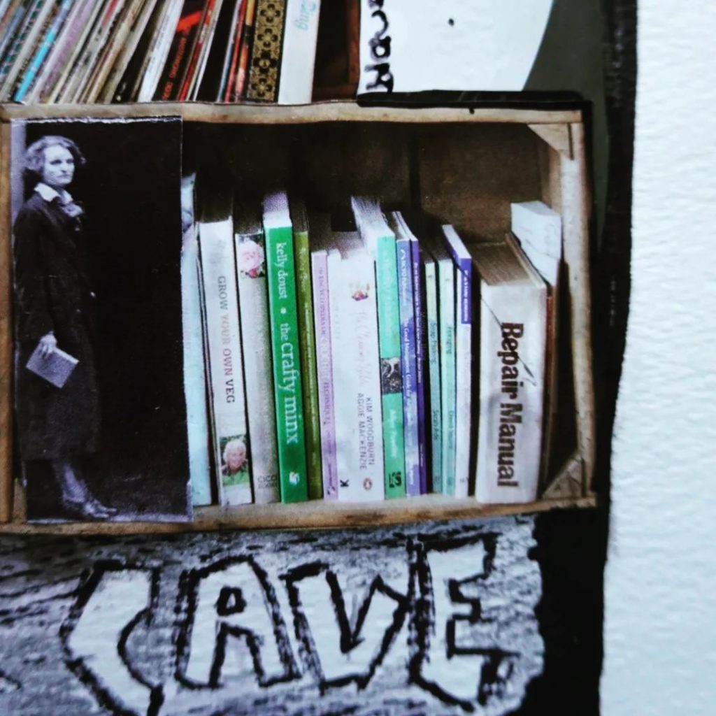 Detail eienr Collage: Sylvia Beach lehnt sin an die Seite eienr Bücherkiste. Darunetr steht das englische Wort für Höhle.