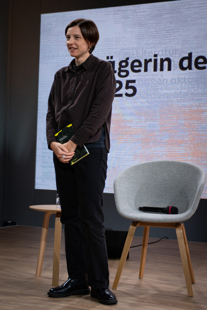 Die Autorin Dorothee Elmiger steht auf der Bühne, um sich von der Presse fotografieren zu lassen.