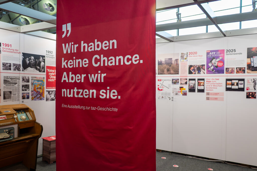 Ausstellung am Stand der taz zu ihrer Geschichte.