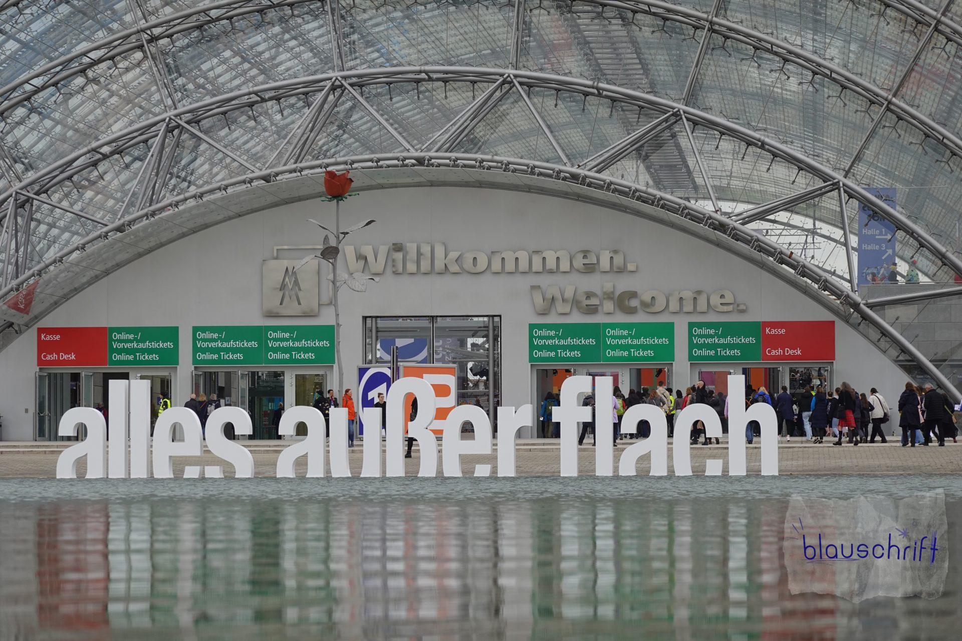 Der Haupteingang der Leipziger Buchmesse: Im Wasser das Jahresmotto des Gastlandes mit großen Buchstaben aufgestellt.