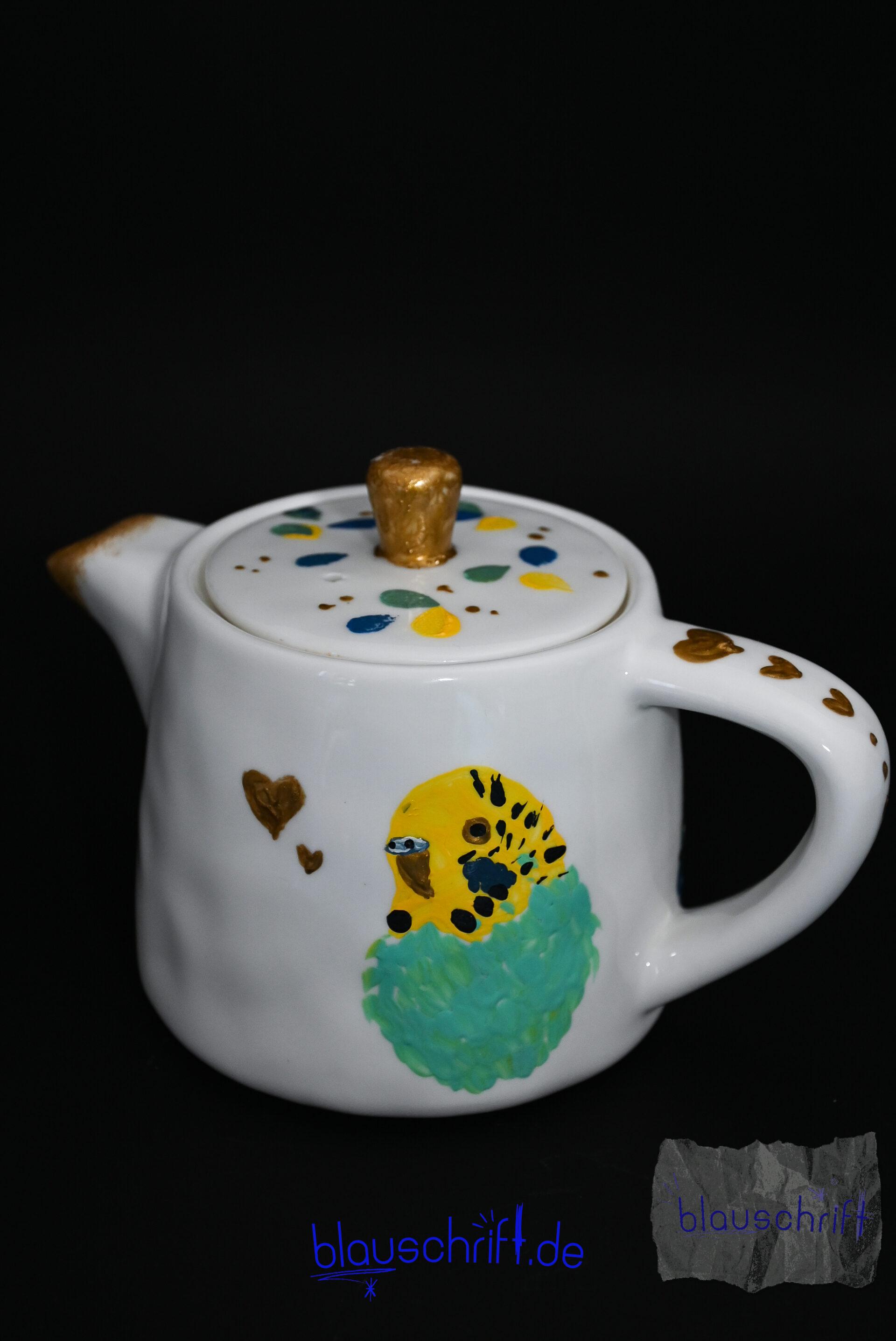 Weiße Teekanne, auf die ein Wellensittich gemalt ist