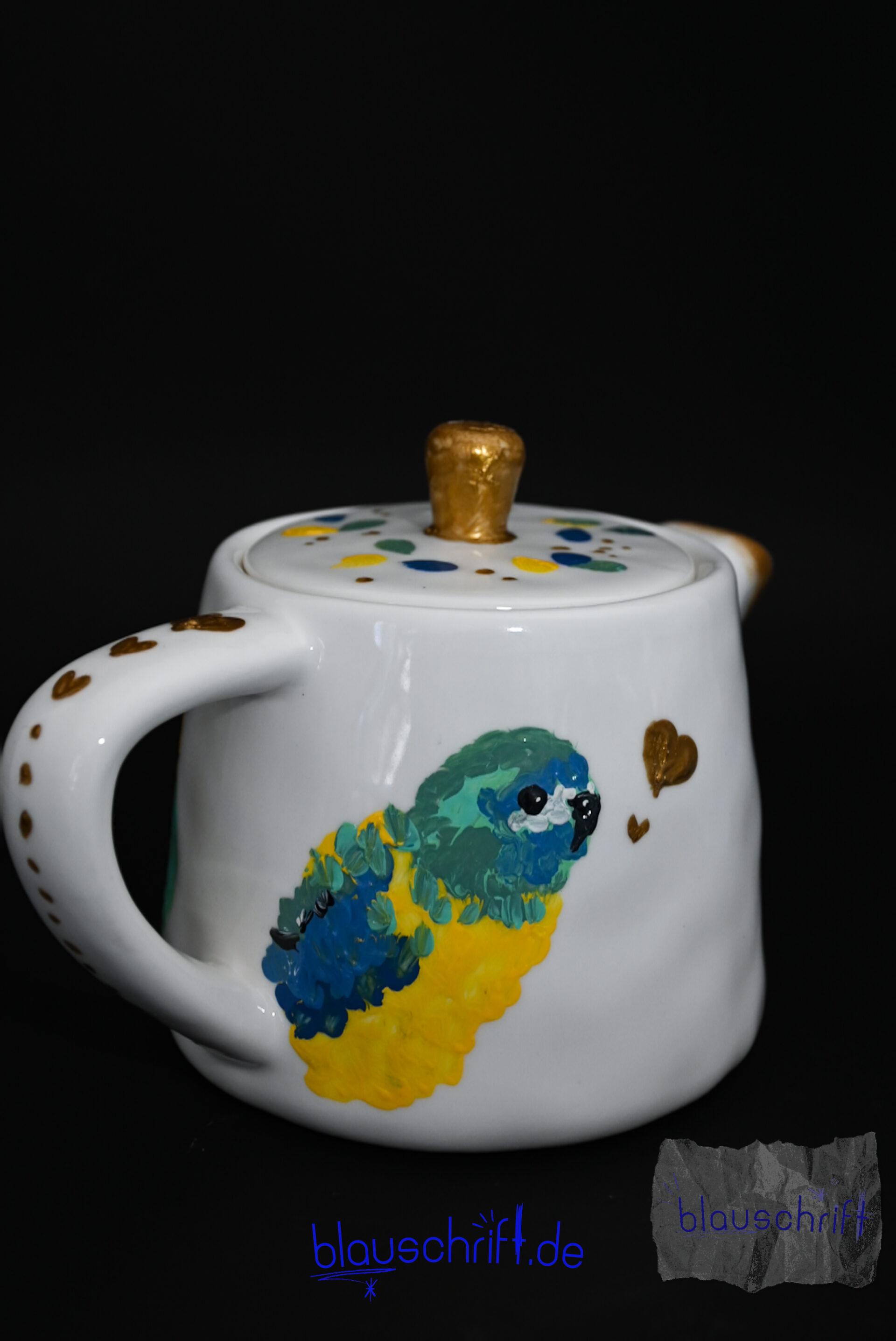 Weiße Teekanne, auf die ein Schönsiitich gemalt ist