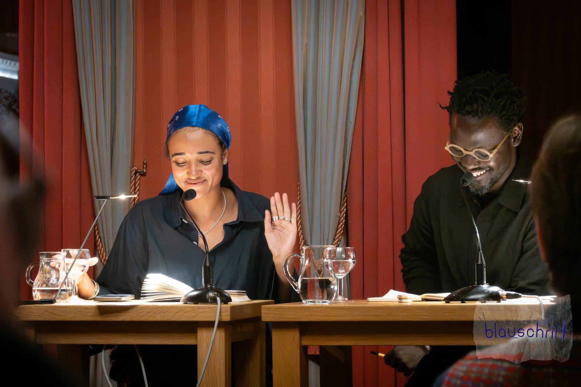 Raphaëlle Red und Ibou C. Diop lachen an den Lesungstischen.